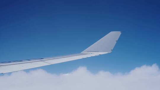 飞机上看窗外机翼划过蓝天白云视频素材模板下载