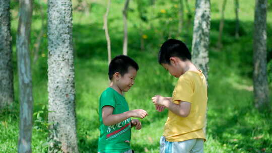 两个小孩在树林里捉虫子 玩蚱蜢 蝗虫