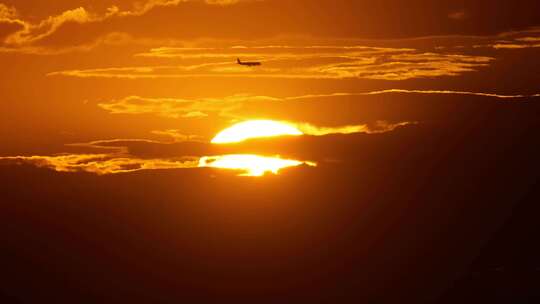 日落十分太阳上空有飞机飞过