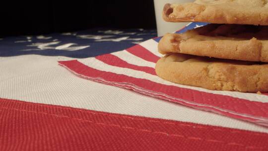 美国国旗上放着的几块饼干和牛奶