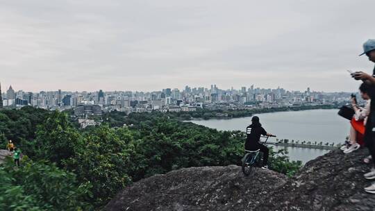 小轮车手在宝石山上俯瞰杭州城市