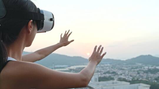 女人在屋顶上体验虚拟现实设备视频素材模板下载