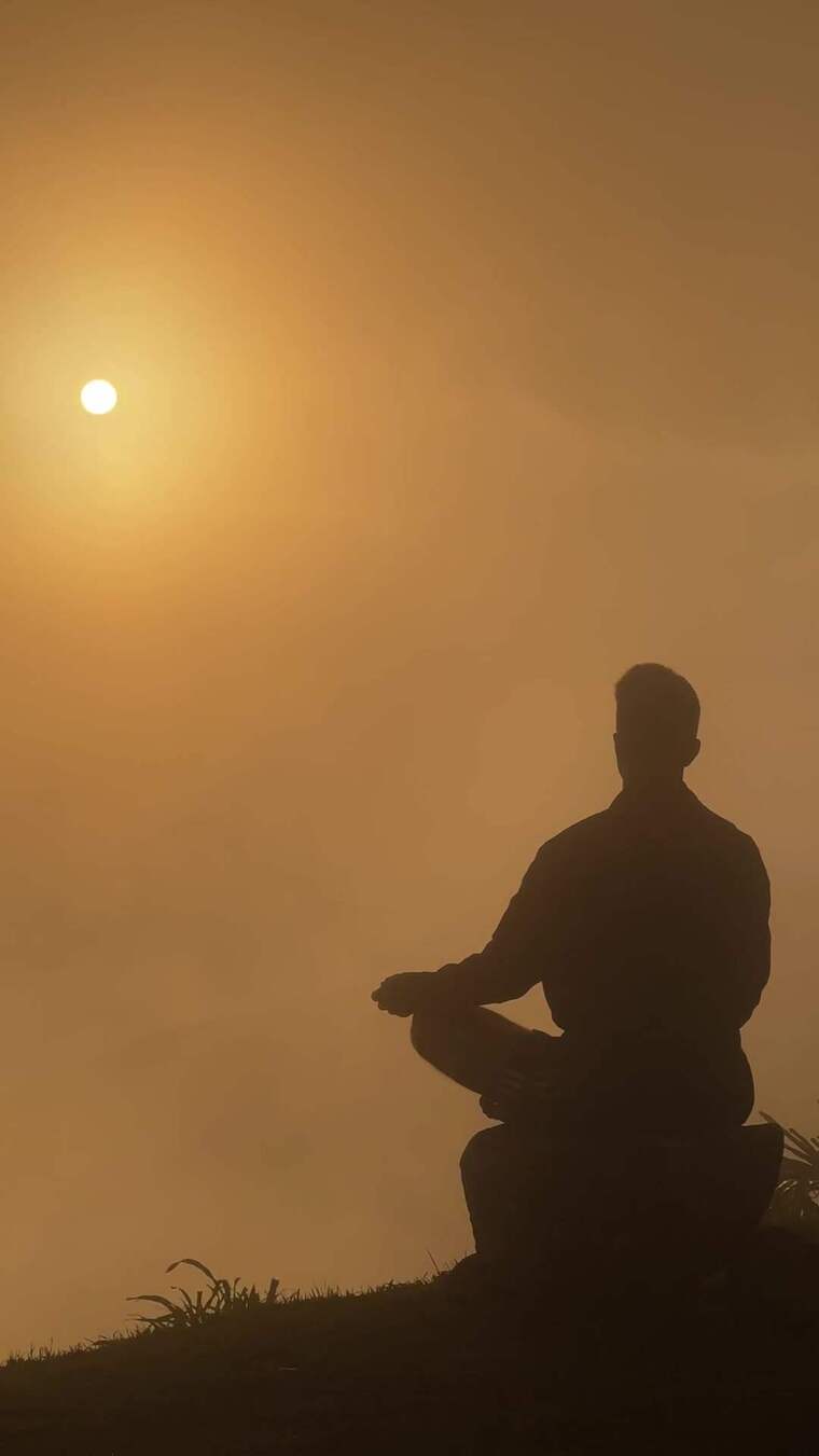 男子日出时户外静坐冥想