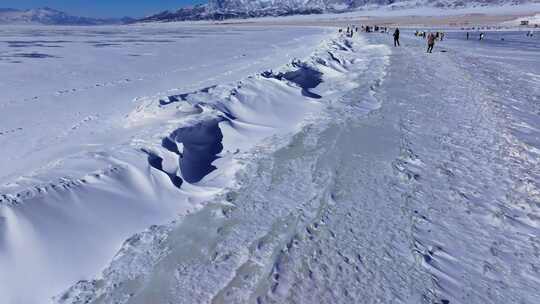 航拍新疆冬季赛里木湖冰封湖面雪山冰湖积雪