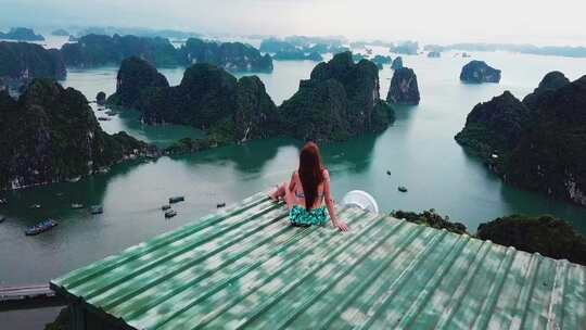 女人坐在屋檐看山脉海景