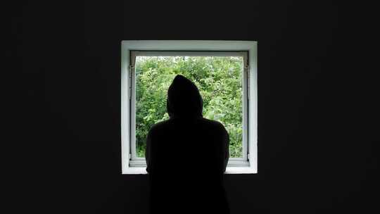 男人在窗户前看向窗外早上早晨起床