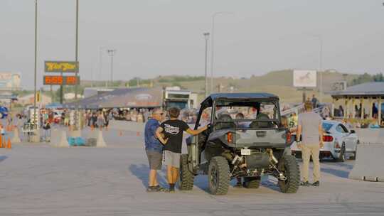 户外场地中人们围着越野车交流 悍马赛车