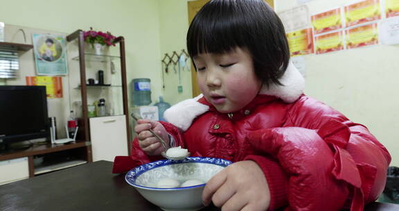 小孩在吃新年春节吃元宵汤圆