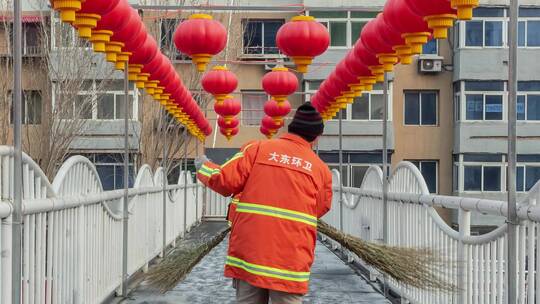 冬季北方环卫工人清扫挂着红灯笼的过街天桥