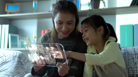 亚洲妈妈和女儿玩一个先进的平板电脑模型