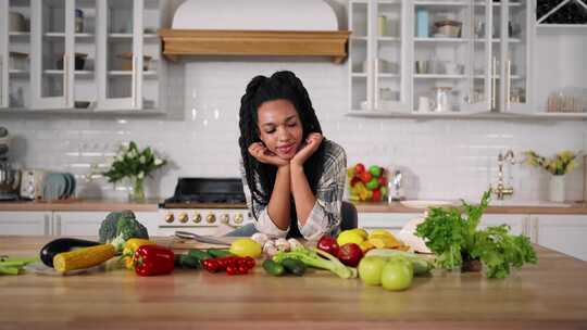 漂亮的素食主义黑人妇女的肖像坐在餐桌旁，