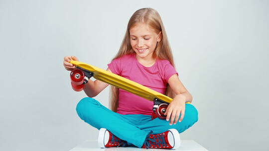 女孩抱着滑板坐在地板上