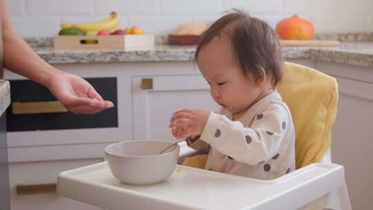 妈妈教女婴独自吃食物