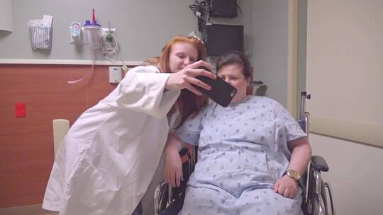 病房内护士和病人用智能手机自拍 