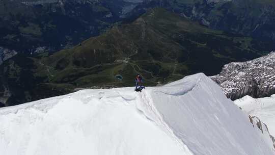 航拍爬上雪山山顶的男子一览众山