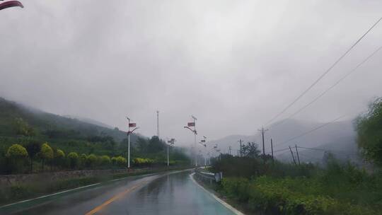 车内视角看雨天崎岖道路远方的山景