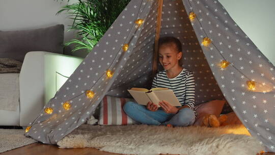 坐在帐篷里的读书女孩