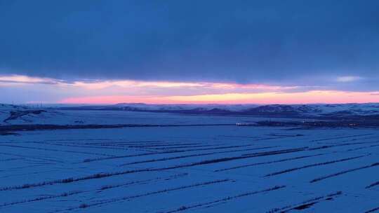 航拍浓郁夕阳下的垦区雪原