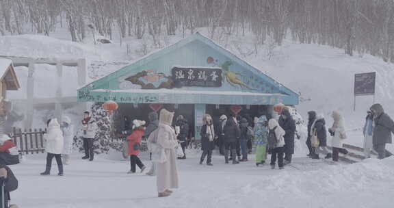 雪地上的彩色小屋及穿着厚外套的人群