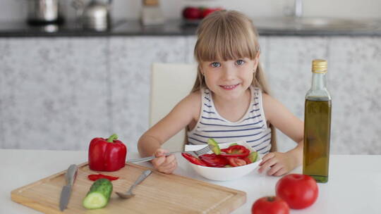 小女孩坐在餐桌前吃蔬菜沙拉视频素材模板下载
