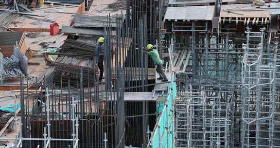 建筑工地工人在钢筋架上作业