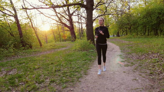女人在阳光照耀下的森林里慢跑