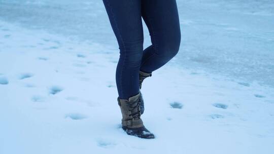 女孩踩在雪地上留下脚印视频素材模板下载