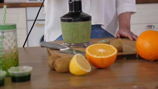 一个女人在搅拌机里搅拌微绿色蔬菜和新鲜水视频素材模板下载