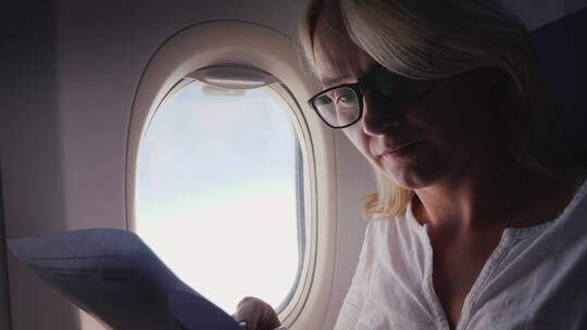 女性在飞机上阅读文件