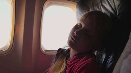 小女孩睡在飞机的客舱里