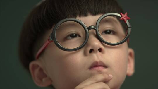 戴眼镜小男孩思考样子视频素材模板下载