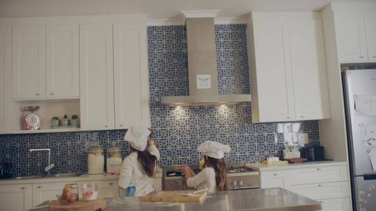 两个小女孩在厨房里尝试做饭