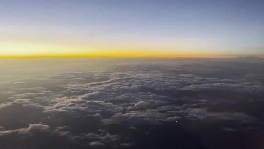 云层之上飞机舷窗外的傍晚自然风光