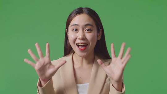 亚洲女商人展示手势手掌说哇和微笑在绿色屏幕