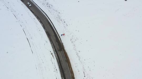 航拍汽车行驶在冰天雪地的川藏公路上