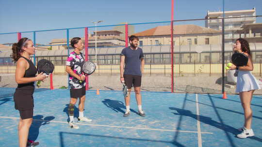 Padel教练在外部领域向她的学生解释体