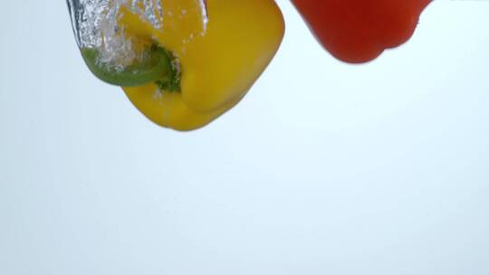 红辣椒和黄辣椒倒入水中的慢镜头
