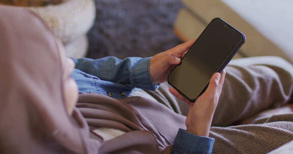 女人坐在家里使用智能手机