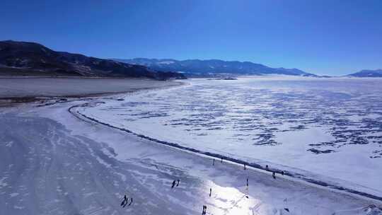 航拍新疆冬季赛里木湖冰封湖面雪山冰湖积雪