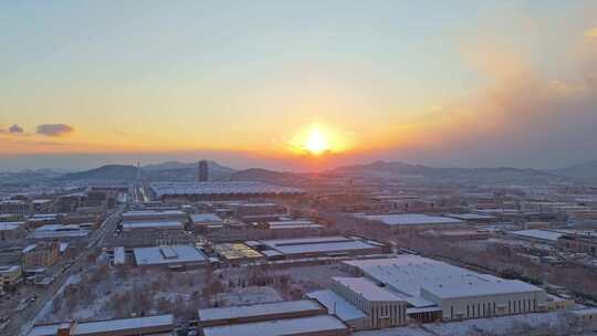 冬季航拍大雪中的城市建筑逆光晚霞风景