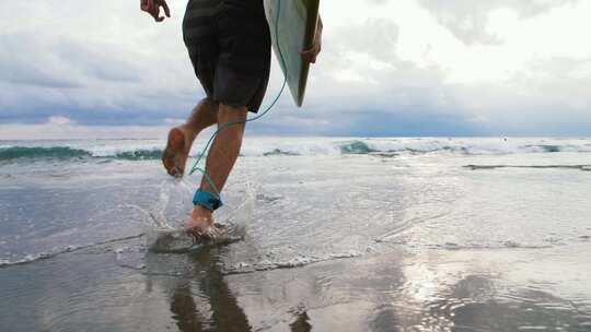 男子拿着冲浪板跑向大海冲浪