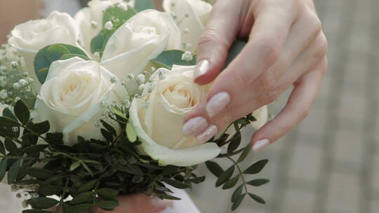 新娘手触摸婚礼花束