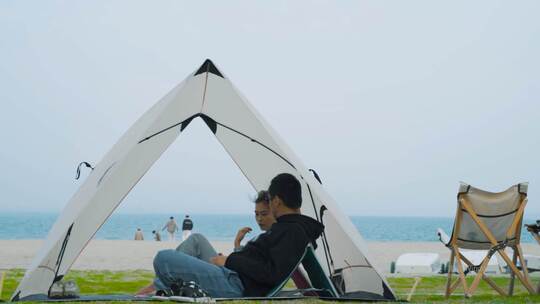 在海边帐篷里聊天的情侣
