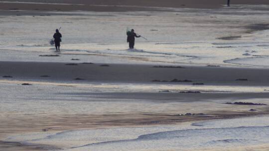 冬季沙滩上的赶海人视频素材模板下载