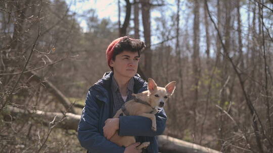 抱着小狗在森林散步的女人视频素材模板下载