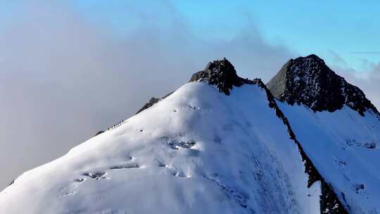 航拍攀登横断山脉乌库楚雪山山脊上的登山者