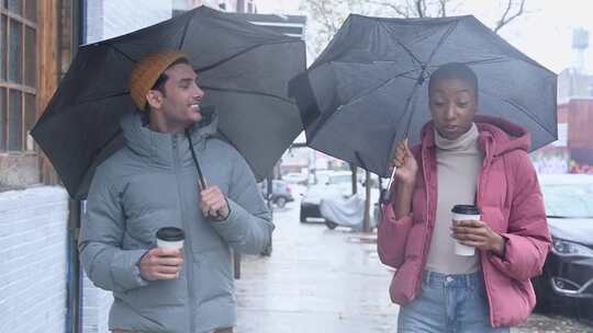 拿着雨伞走在人行道上的夫妇