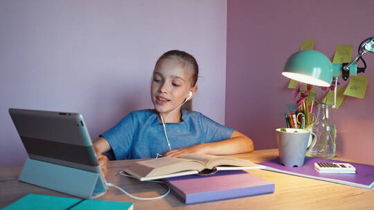 女孩带着耳机用平板电脑听课视频素材模板下载