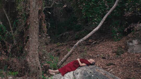 和尚躺在森林的石头上冥想