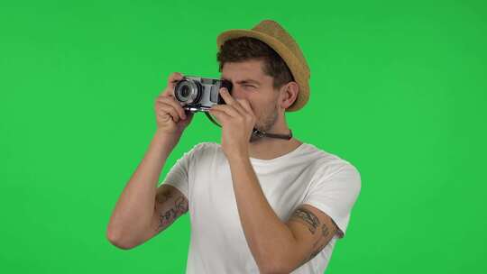 度假时戴帽子的游客肖像在复古相机上拍照